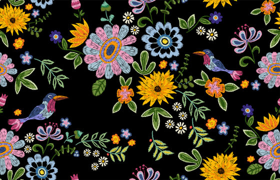 Embroidery ethnic seamless pattern with birds and flowers. Vector embroidered floral design for fabric.