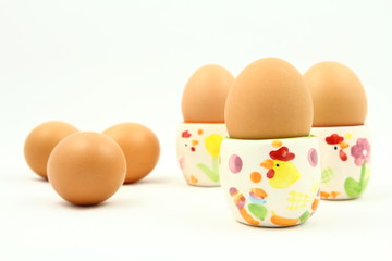 Wielkanoc - śniadanie - jajka na kolorowych podstawkach - białe tło © Cezzar