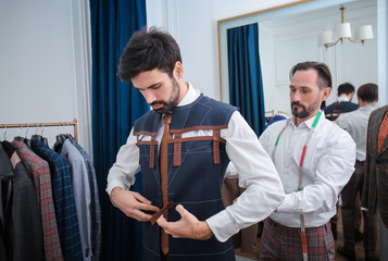 Tailor with client in atelier. Sewing custom made suit