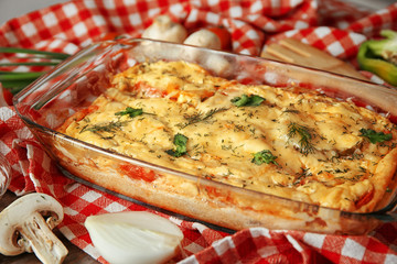 Glass baking dish with delicious casserole on table, closeup. Fresh from oven