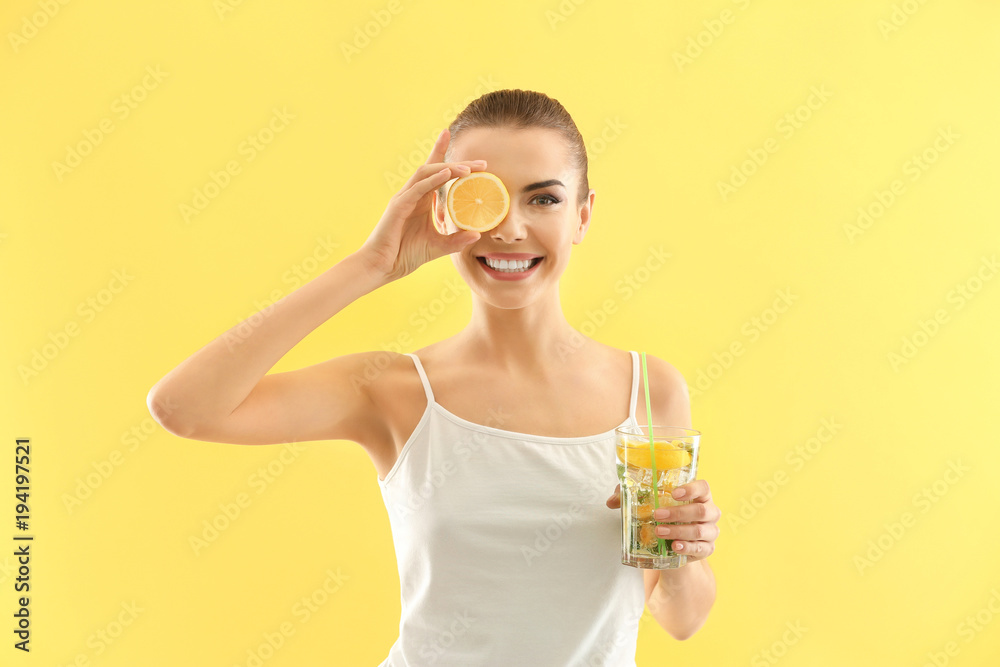 Wall mural beautiful young woman with glass of lemonade on color background