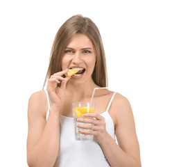 Beautiful young woman with glass of lemonade on white background