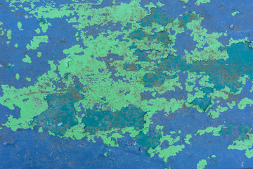 Texture of old shabby peeling green paint on a blue surface