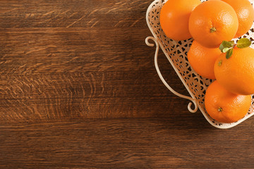 Tray with juicy ripe oranges on wooden background, top view