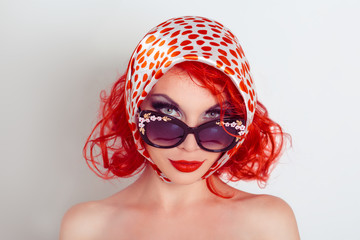 Funny girl in retro style. Studio photo of the girl in sunglasses and a scarf fun