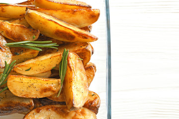 Dish with tasty potato wedges, closeup