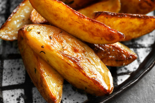Plate with tasty potato wedges, closeup