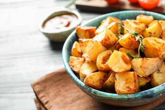 Bowl with tasty potato wedges on table
