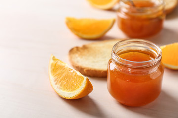 Jar with sweet jam on wooden table