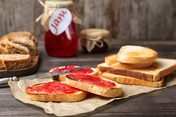 Delicious toasts with sweet jam on wooden table