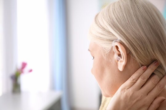 Mature Woman With Hearing Aid Indoors