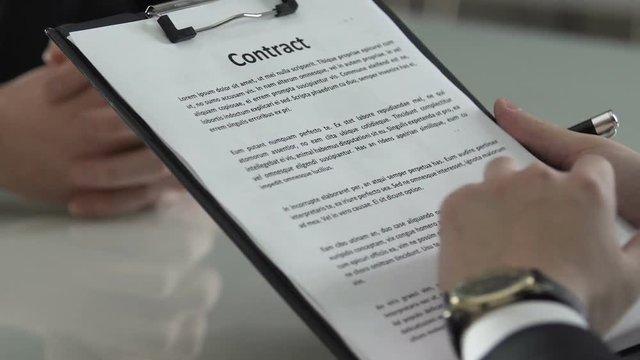 Man signing contract with dollar bills inserted, venality and financial crime