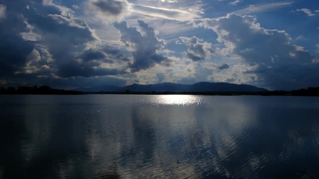 The lake has a reflection of the clouds and the sky. 