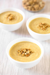 Hausgemachter Rhabarbermousse mit Knuspermüsli bestreut, fotografiert mit natürlichem Licht (Selektiver Fokus, Fokus in die Mitte des ersten Desserts)