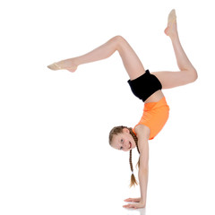 Fototapeta premium The gymnast performs a handstand with bent legs.