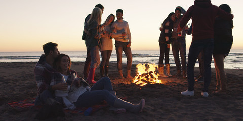 Friends having fun at beach on autumn day