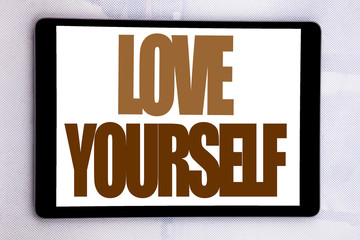 Hand writing text caption inspiration showing Love Yourself. Business concept for Positive Slogan For You written on tablet screen on the white background.