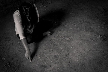 Give me support. Poor depressed woman folding her legs and sitting on the floor while writing help me