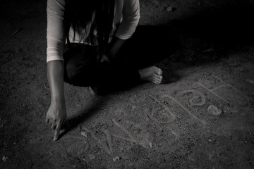 Give me support. Poor depressed woman folding her legs and sitting on the floor while writing help me