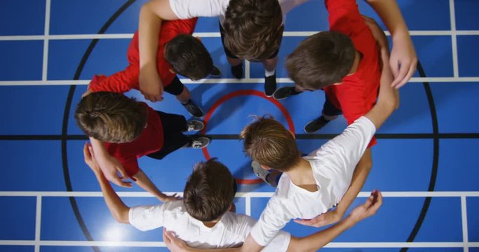 4k, School kids stacking hands in basketball court at school gym.