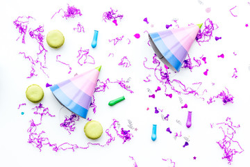 Birthday party accessories. Party hat, sweets, confetti on white background top view copy space