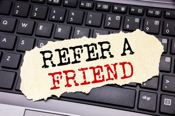 Writing text showing Refer A Friend. Business concept for Referral Marketing written on sticky note paper on the black keyboard background.