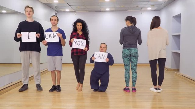 People turns to camera with motivation boards