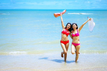 Couple friends, Asian women enjoy  on the beach during at summer vacations, summer holidays, travel, people and vacation concept.