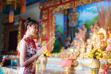 Asian woman wearing chinese dress, smile in chinese new year, Chinese woman dress traditional cheongsam at Chinese Temple.