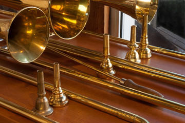 3 sackbuts and 5 mouthpieces on a table