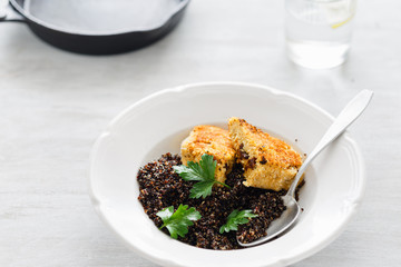 Vegetarian dinner table. Plate with black quinoa and oatmeal cutlets with prunes on white wooden table close up