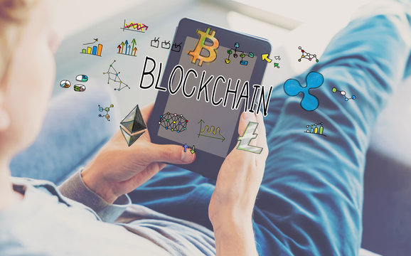 Blockchain with man using a tablet in a chair