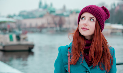 Portriat of young redhead girl in hat and coat in Prague