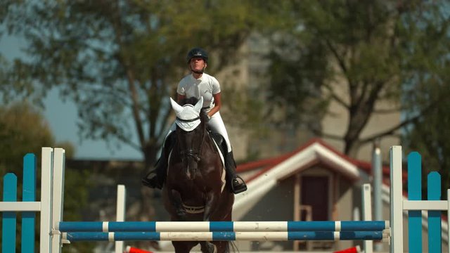 Riding a horse over obstacle in slow motion