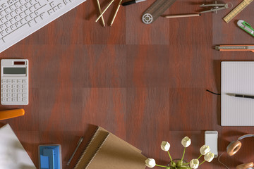 Top view of wood table office with Keyboard, Pencil, Ruler, Half circle, Cutter, note paper, Mobile phone, Headphones, Tulip, whole puncher and calculator.