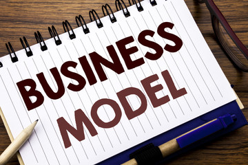 Hand writing text caption inspiration showing Business Model. Business concept for Solution Strategy Plan Written on notebook note paper, wooden background with glasses pen and marker.
