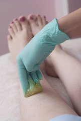 Female legs depilation with sugar pasta. Beauty Cosmetic Procedure for Girls.