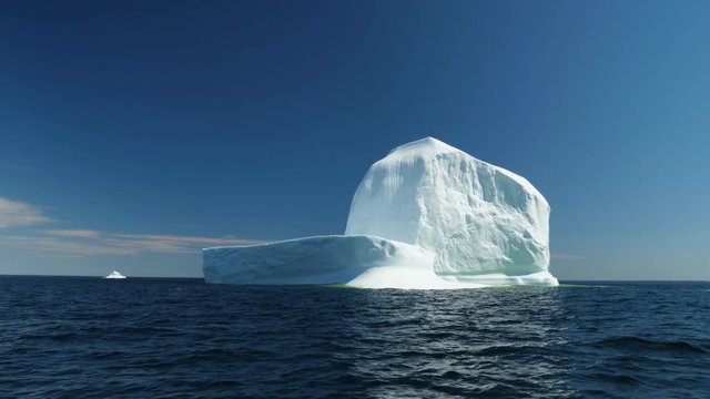Immense ice berg floats off a coast in a cold sea