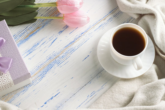 Pink Tulips, White Scarf, Coffee Cup and Gift Box on a White Wooden Background