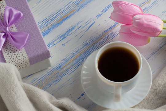 Pink Tulips, Scarf, Coffee Cup and Gift Box on a White Wooden Background