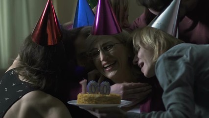 Grandchildren hugging old happy woman on 100 birthday party, family closeness