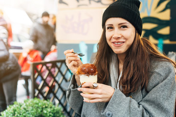 Happy girl eating dessert in a cafe