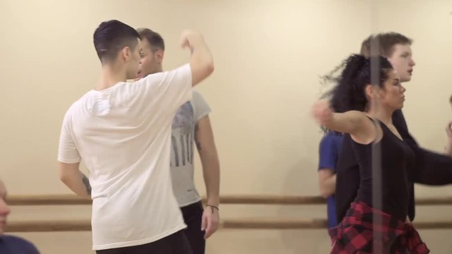 Attractive people are dancing in the light studio