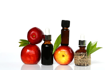 peach  oil.natural peach   oil in dark glass bottles and fresh peach fruit on white background