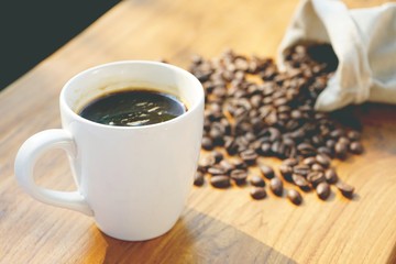 Morning cup of coffee with coffee bean background on wooden table