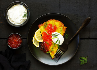 Potato rusty (potato pancake) with red caviar. View from above.