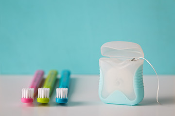 Colorful toothbrushes and dental floss, close up.  - obrazy, fototapety, plakaty