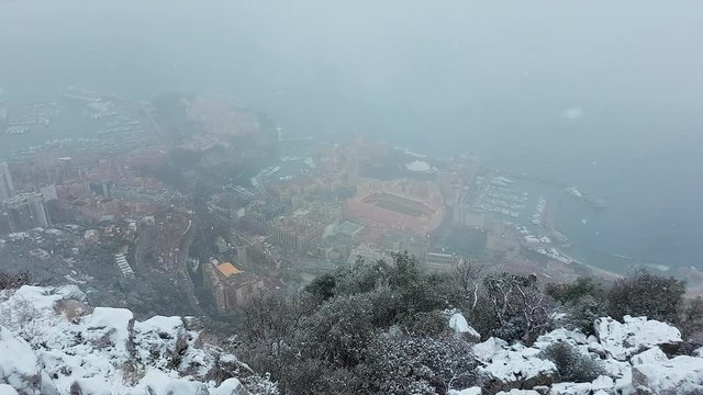 Beautiful Panoramic Aerial View of Monaco Under The Snow. Snow is Falling. Landscape of The French Riviera in Winter - 4K Video
