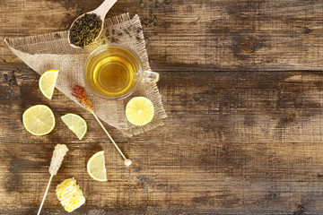 A mug of tea with lemon slices and sugar on a stick