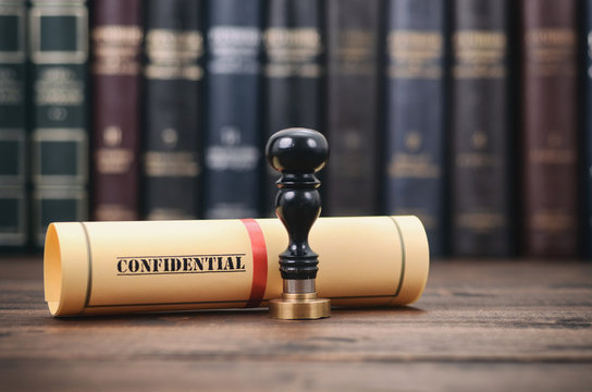 Confidential type of document and notary seals on the wooden background.